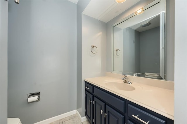 bathroom with tile patterned flooring, vanity, baseboards, and toilet