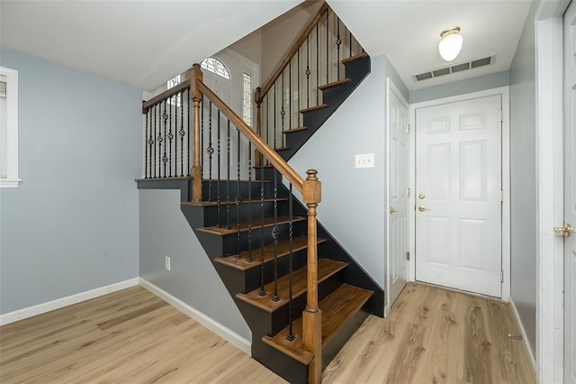 staircase featuring wood finished floors and baseboards