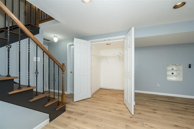 stairs with wood finished floors and baseboards