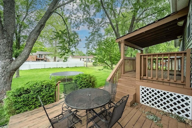 deck featuring outdoor dining space and a trampoline