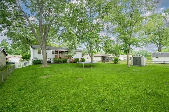 view of yard featuring a trampoline and a wooden deck