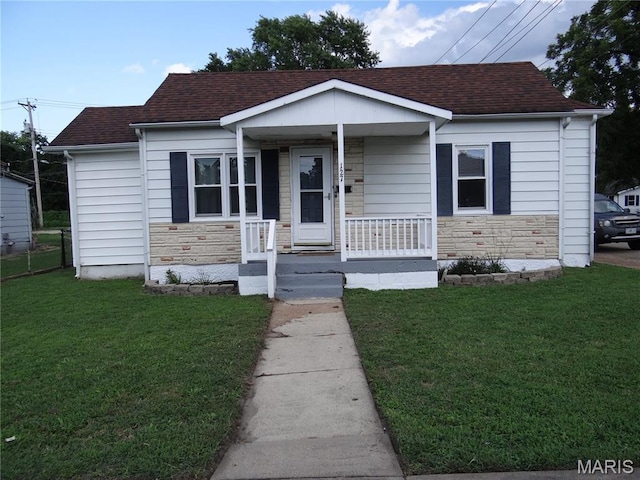 127 E 2nd St, De Soto, MO 63020 - bungalow-style house with stone siding, a porch, a front yard, and a shingled roof