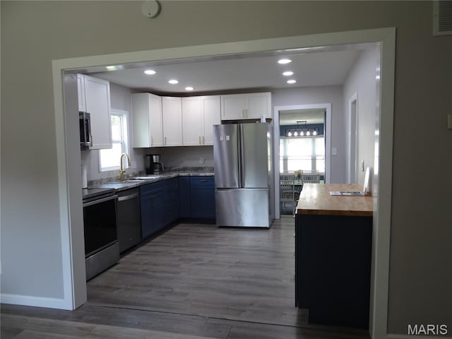 127 E 2nd St, De Soto, MO 63020 - kitchen featuring stainless steel appliances, wood counters, white cabinets, recessed lighting, and wood finished floors