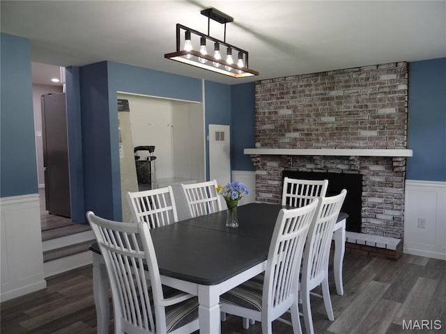 127 E 2nd St, De Soto, MO 63020 - dining area featuring a wainscoted wall, wood finished floors, and a decorative wall