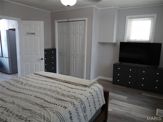 127 E 2nd St, De Soto, MO 63020 - bedroom with freestanding refrigerator, ornamental molding, wood finished floors, and a closet