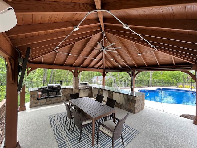 view of pool with an outdoor kitchen, a gazebo, a fenced backyard, and a patio area
