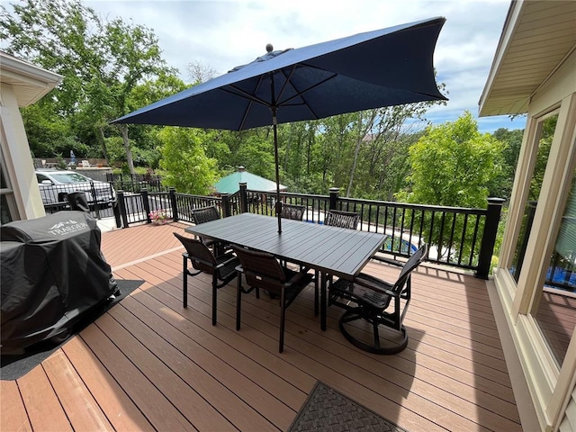 wooden deck with outdoor dining area and view of scattered trees