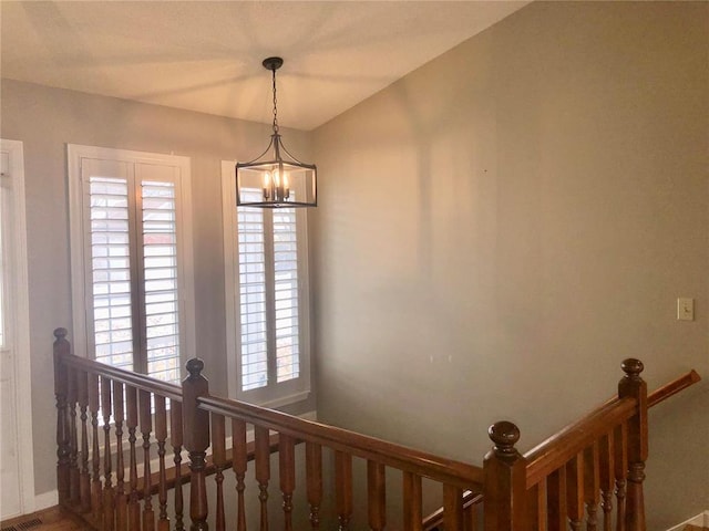 staircase featuring a chandelier and baseboards