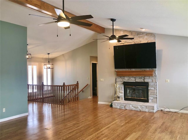 living room with wood finished floors, a fireplace, baseboards, and a chandelier
