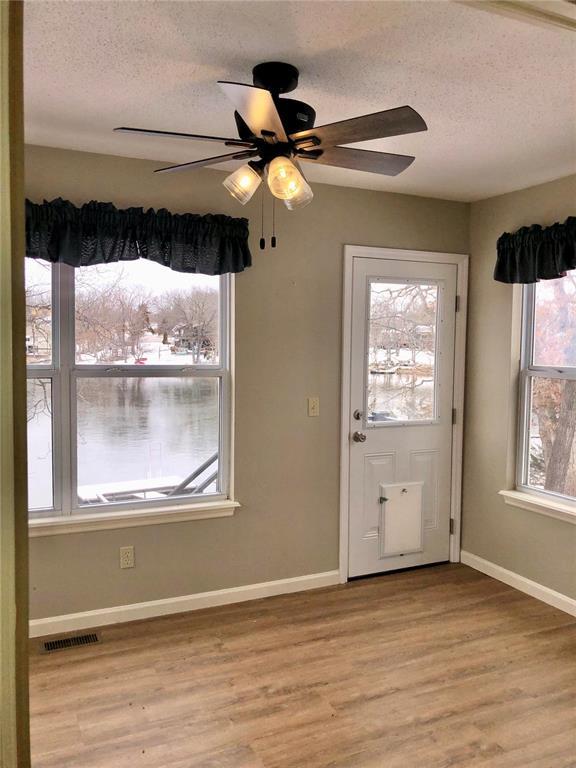 entrance foyer featuring a textured ceiling, light wood-style flooring, baseboards, and a ceiling fan