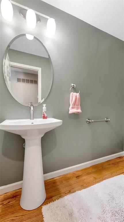 bathroom with wood finished floors and baseboards