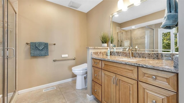 bathroom featuring toilet, a stall shower, baseboards, vanity, and tile patterned floors