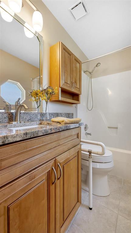 bathroom with tile patterned floors, toilet, vanity, and shower / bathtub combination