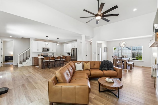 1513 Grey Wolf Dr, Imperial, MO 63052 - living room featuring a ceiling fan, stairs, light wood-style floors, and recessed lighting