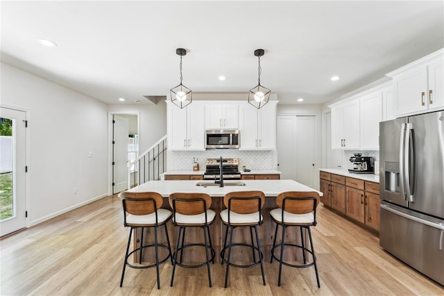 1513 Grey Wolf Dr, Imperial, MO 63052 - kitchen featuring appliances with stainless steel finishes, decorative backsplash, light countertops, light wood finished floors, and white cabinetry