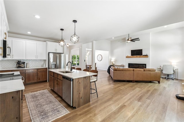 1513 Grey Wolf Dr, Imperial, MO 63052 - kitchen with stainless steel appliances, a sink, white cabinets, light countertops, and open floor plan