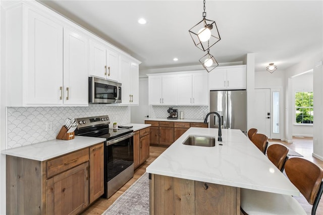 1513 Grey Wolf Dr, Imperial, MO 63052 - kitchen featuring appliances with stainless steel finishes, a sink, a breakfast bar, a kitchen island with sink, and tasteful backsplash