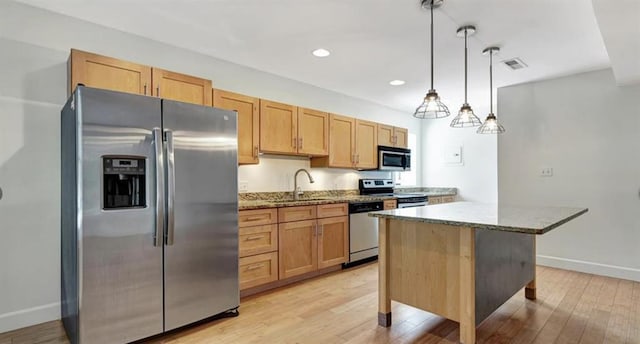 4220 Mcpherson Unit 101, Saint Louis, MO 63108 - kitchen featuring appliances with stainless steel finishes, a sink, light stone countertops, baseboards, and light wood-style floors