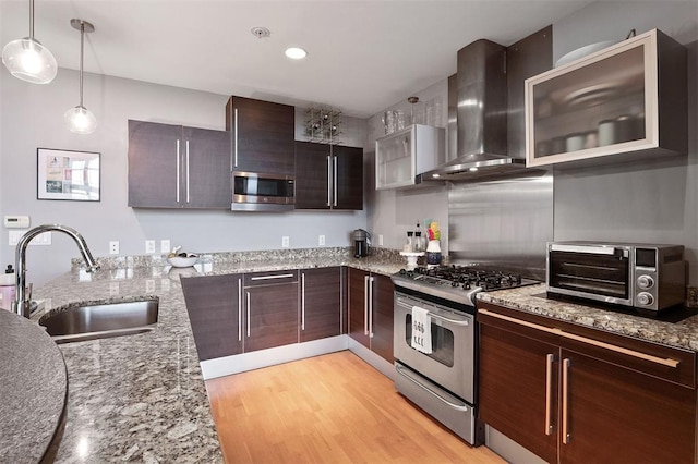 4100 Forest Park Ave Unit 323, Saint Louis, MO 63108 - kitchen featuring stainless steel appliances, a sink, wall chimney range hood, light wood-type flooring, and light stone countertops