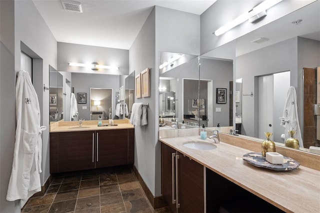4100 Forest Park Ave Unit 323, Saint Louis, MO 63108 - bathroom with baseboards, stone tile floors, and vanity