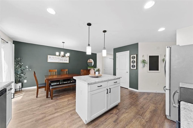 224 Quiet Bend Dr, Wentzville, MO 63385 - kitchen with a chandelier, white cabinets, light wood-style floors, baseboards, and hanging light fixtures