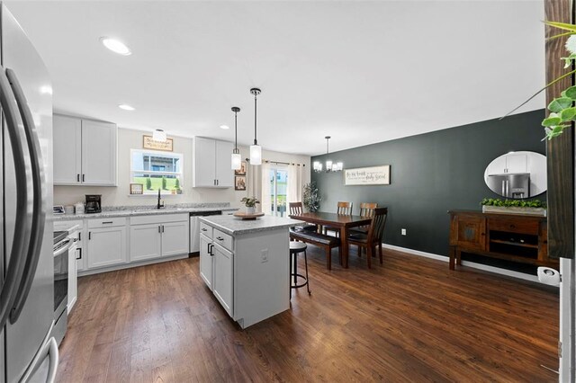 224 Quiet Bend Dr, Wentzville, MO 63385 - kitchen with a sink, appliances with stainless steel finishes, a center island, dark wood finished floors, and a breakfast bar area