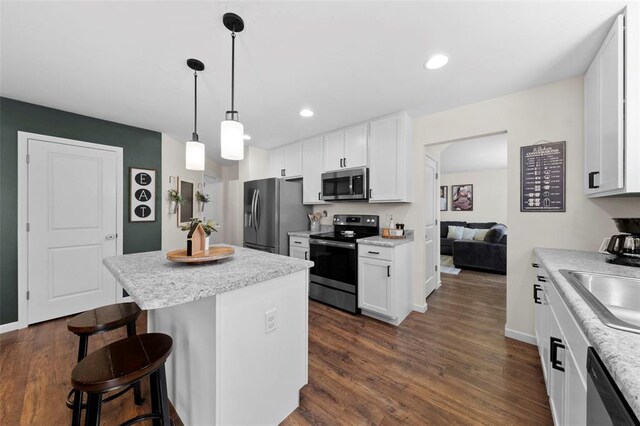224 Quiet Bend Dr, Wentzville, MO 63385 - kitchen with appliances with stainless steel finishes, a kitchen breakfast bar, a center island, white cabinetry, and recessed lighting