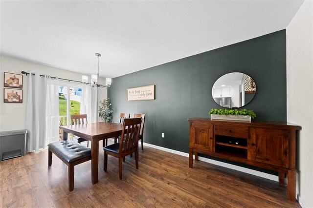 224 Quiet Bend Dr, Wentzville, MO 63385 - dining room with a chandelier, wood finished floors, and baseboards