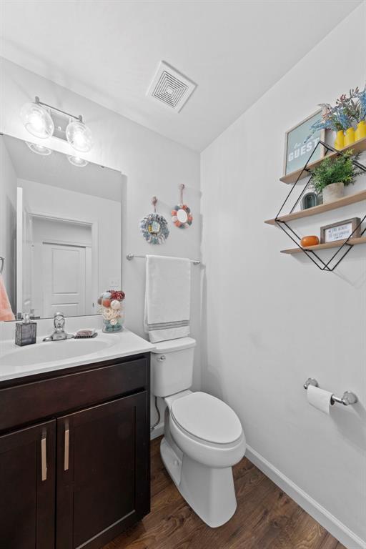 224 Quiet Bend Dr, Wentzville, MO 63385 - half bathroom with toilet, vanity, and wood finished floors