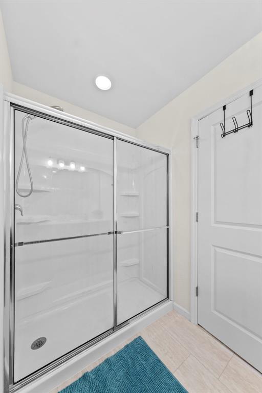 224 Quiet Bend Dr, Wentzville, MO 63385 - bathroom with a stall shower, baseboards, and tile patterned flooring