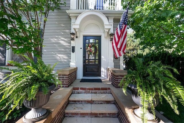 view of exterior entry featuring a balcony