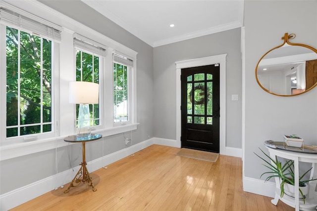 entryway with baseboards, wood-type flooring, and ornamental molding