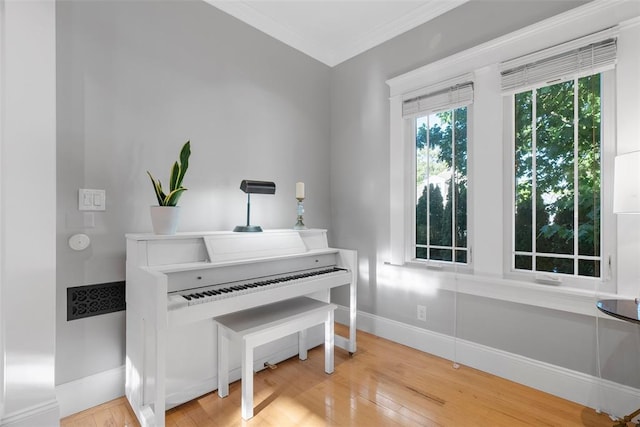 sitting room with wood finished floors, baseboards, and ornamental molding