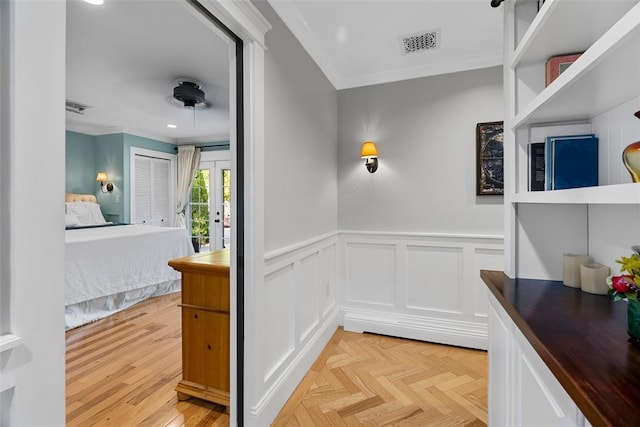 corridor with ornamental molding, wainscoting, a decorative wall, and recessed lighting