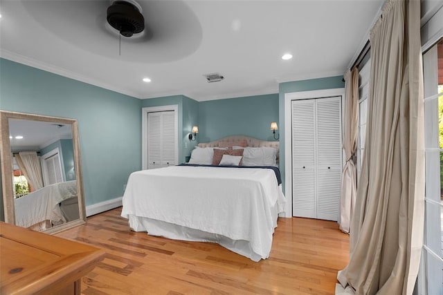 bedroom with crown molding, light wood-style floors, multiple closets, baseboards, and recessed lighting