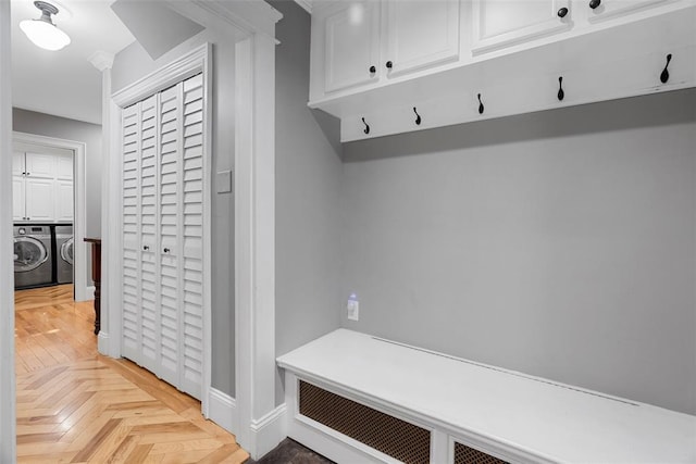 mudroom with washer and dryer and baseboards
