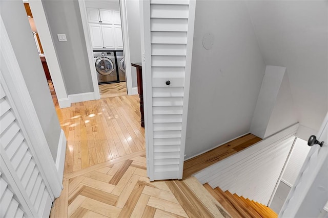 hallway featuring independent washer and dryer and baseboards