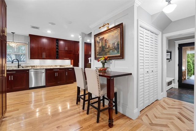 kitchen featuring stainless steel dishwasher, reddish brown cabinets, a sink, light stone countertops, and baseboards