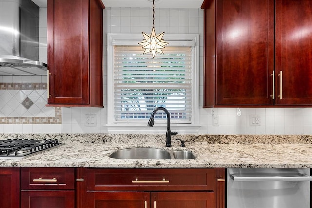 kitchen featuring stainless steel appliances, wall chimney range hood, a sink, and dark brown cabinets