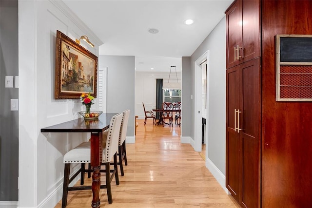 hallway with light wood finished floors, baseboards, and recessed lighting