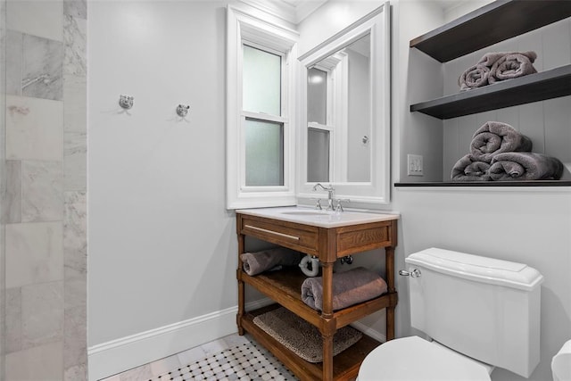 bathroom featuring toilet, baseboards, tiled shower, vanity, and tile patterned floors