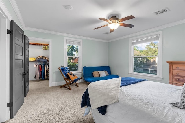 bedroom with ornamental molding, light colored carpet, a spacious closet, a ceiling fan, and baseboards