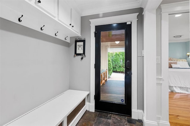 mudroom featuring crown molding, baseboards, and dark stone finish flooring
