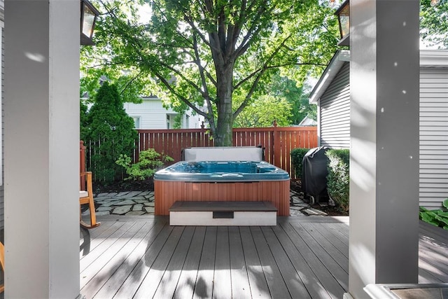 wooden deck with a hot tub, a grill, and fence