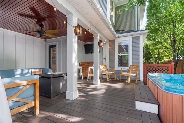 deck featuring a hot tub and a ceiling fan