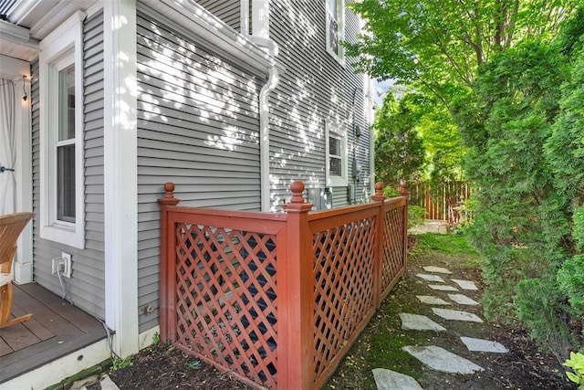 view of side of property with fence and a wooden deck