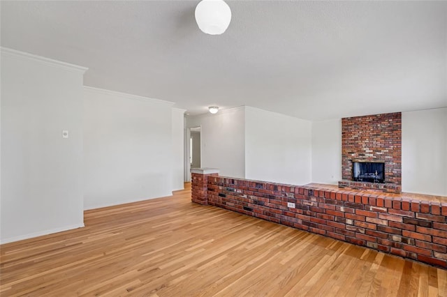 10014 Aldred Dr, Sunset Hills, MO 63128 - unfurnished living room with light wood finished floors, a brick fireplace, crown molding, and baseboards