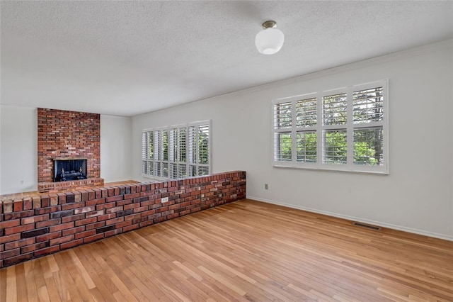 10014 Aldred Dr, Sunset Hills, MO 63128 - living room with hardwood / wood-style floors, baseboards, a textured ceiling, and a fireplace