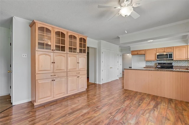 10014 Aldred Dr, Sunset Hills, MO 63128 - kitchen with appliances with stainless steel finishes, light wood finished floors, glass insert cabinets, ceiling fan, and ornamental molding