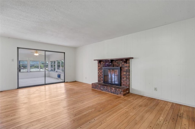 10014 Aldred Dr, Sunset Hills, MO 63128 - unfurnished living room featuring hardwood / wood-style floors, a fireplace, and a textured ceiling